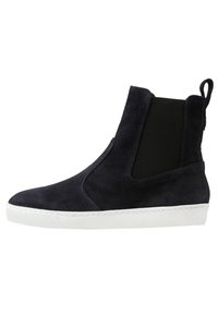 Bottes chelsea en suède bleu marine avec des panneaux élastiques sur les côtés, un bout arrondi et une semelle en caoutchouc blanc. Design minimaliste avec une languette à l'arrière.