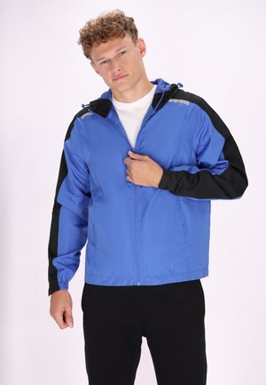 Jachetă din nylon albastră cu accente negre, cu fermoar frontal și glugă. Prezintă manșete elastice și o croială lejeră. Design simplu pentru purtare casuală.