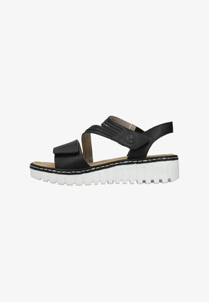 Schwarze Ledersandalen mit mehreren Riemen und einem Klettverschluss auf einer erhöhten weißen Plattformsohle mit strukturierten Akzenten.