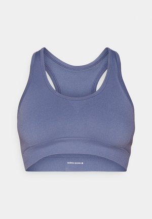 Sporta krūšturis vidēji purpura krāsā, izgatavots no stiepjama auduma. Tam ir apaļš kakla izgriezums, sacensību aizmugure un zīmola elastīga lente apakšā.