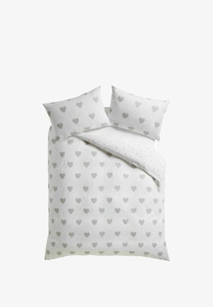 Doppelbett mit weißer Bettwäsche und Kissenbezügen, die mit einem sich wiederholenden Muster aus hellgrauen Herzen dekoriert sind.