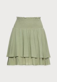 Gonna a strati verde chiaro con vita elasticizzata arricciata e bordo superiore arricciato su sfondo bianco.