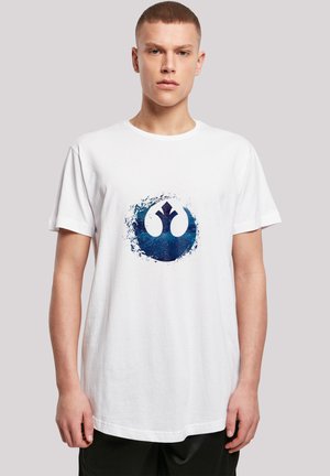 Hvit bomulls t-skjorte med et stort, blått, sirkulært grafisk motiv med et stilisert emblem i midten. Korte ermer og rund halsdesign.