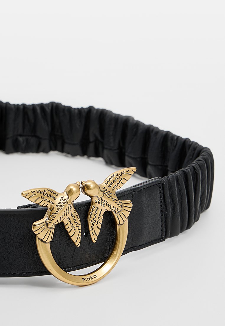 Czarny skórzany pasek o marszczonym wzorze, z zapięciem w kolorze złota w kształcie dwóch ptaków w okrągłej obręczy.