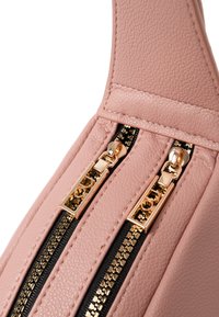Borsa in ecopelle rosa con doppie cerniere nere e hardware dorato, superficie testurizzata e design strutturato.