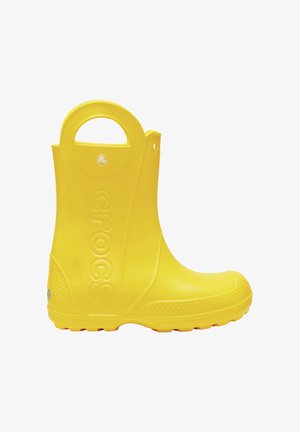 Bota de lluvia de goma amarilla con un acabado suave, punta redondeada y suela texturizada. Cuenta con un asa en la parte superior y un diseño de logo en relieve.