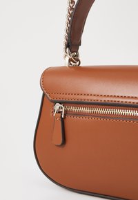 Borsa a tracolla in finta pelle marrone con chiusura a zip, hardware tono oro e tracolla a catena. Presenta una texture liscia e cuciture a contrasto.
