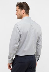 Gestreiftes Langarmshirt in Weiß und Marineblau, mit klassischem Kragen und Knopfmanschetten, ausgestattet mit einer taillierten Passform und einem Rückeneinsatz.