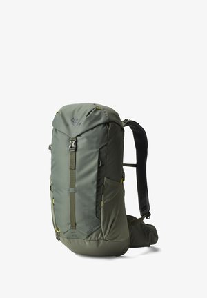 Green hiking backpack with multiple compartments, padded shoulder straps, and hip belt, standing upright on a white background.