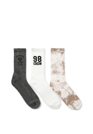 Tre calzini a mezza gamba affiancati: grigio scuro con un disegno di rosa, bianco con il testo "98 CREW" e beige con motivo tie-dye.