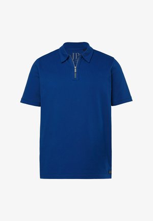 Lyhythihainen, kuninkaansinisä polo-paita, jossa kaulus ja etuosan vetoketjusuljenta, yksivärinen design ja pieni logolla varustettu lappu helman lähellä.