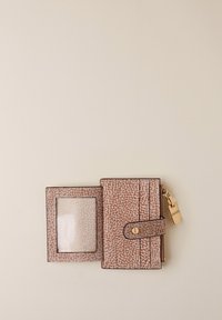 Braun strukturiertes Portemonnaie, geöffnet, um ein klares Ausweisfenster, Kartenfächer, Druckverschluss und einen goldenen Reißverschluss mit Marken-Zipper auf beigem Hintergrund zu zeigen.