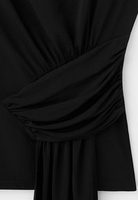 Schwarzer Stoff mit gerafften und verdrehten Details, die drapierte Falten und einen taillierten Effekt an der Kleidung erzeugen.