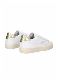 Weiße Ledersneaker mit goldenen Akzenten an der Ferse, ausgestattet mit einer cremefarbenen Sohle und strukturierten Oberflächen. Schnürdesign mit Logodetail.