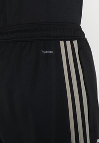 Schwarze Sportshorts aus leichtem Material. Mit grauen Streifen an der Seite, einer Reißverschlusstasche und einem "CLIMACOOL"-Label.