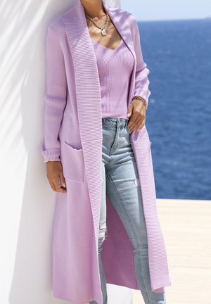 Lichtpaarse cardigan met geribbelde textuur, open voorkant en zijzakken, gedragen over een bijpassende aansluitende top en lichtblauwe beschadigde spijkerbroek.