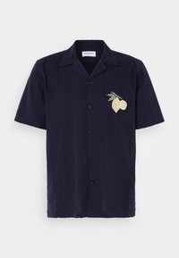 Chemise bleu marine à manches courtes avec boutons, motif texturé et broderie de citron et de feuille sur la poitrine gauche.
