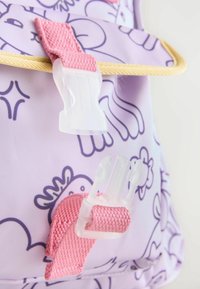Lila ryggsäck med tecknad mönster, med klara plastspännen och rosa tygremmar. Slät textur med en lättviktig design.