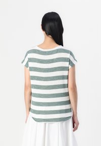 Camiseta de manga corta y cuello redondo en tela a rayas verdes y blancas, con un dobladillo redondeado y textura suave.