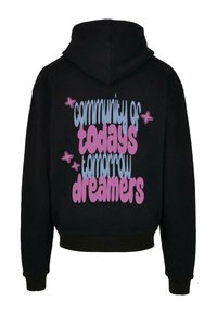 Fekete kapucnis pulóver, amelyen pasztell színekkel készült nagy grafika szerepel, ami a "a mai álmodók közössége" feliratot tartalmazza, kisméretű csillag díszítésekkel.