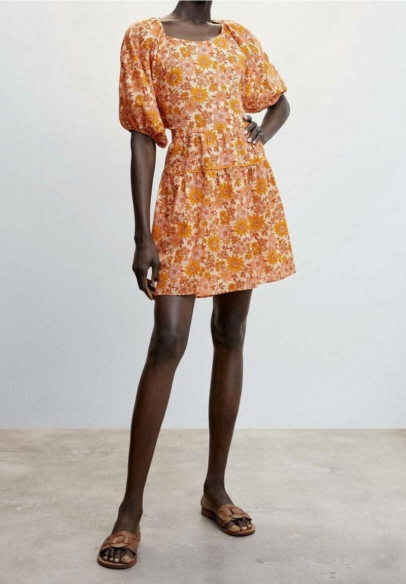 Robe florale orange et rose avec des manches bouffantes, décolleté carré et corsage ajusté, présentant un design de jupe à volants et un tissu léger.