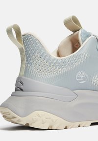 Helleblaue Sneaker mit Mesh-Obermaterial, grauer Gummisohle und gepolstertem Kragen. Mit Baum-Logo und Fersenlasche für ein einfaches Anziehen.