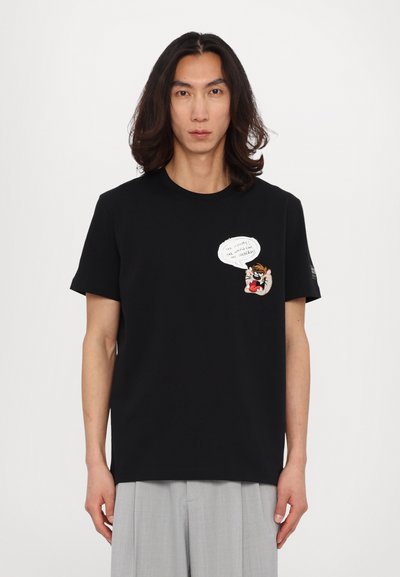 Tricou din bumbac negru, cu un patch cu desen animat pe piept, având un design cu bulă de dialog. Manșete scurte și gât rotund. Stil minimalist.