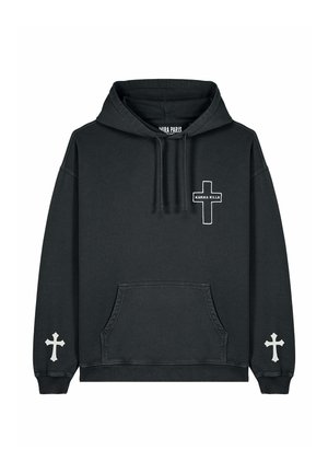 Czarna, oversize bluza z kapturem z kieszenią z przodu, białymi wzorami w krzyż na rękawach i klatce piersiowej, w połączeniu z kremowymi spodniami cargo i białymi trampkami.