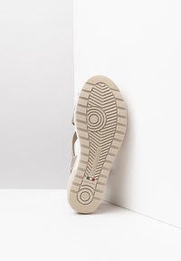 Beige sandal bottom with a textured rubber sole, featuring circular patterns and the brand name "NeroGiardini" embossed. 37 size indicated.