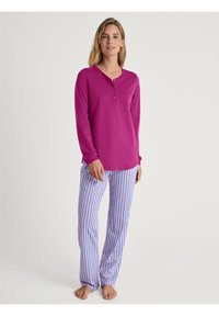 Langharige, felroze henley top met drie knopen, gecombineerd met blauw-witte gestreepte pyjamabroek. Zachte stof, relaxte pasvorm.