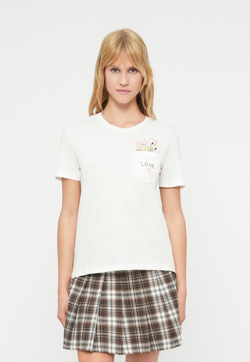 Λευκό βαμβακερό t-shirt με κοντά μανίκια, που διαθέτει τσέπη με λουλουδένιο σχέδιο και τη λέξη "LOVE" σε μαύρο χρώμα. Συνδυασμένο με καρό φούστα.