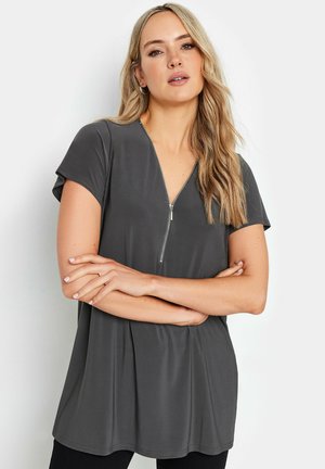 Gray short-sleeve top with a V-neckline and a zipper detail. Soft fabric with a relaxed fit and gentle pleats at the hem.
