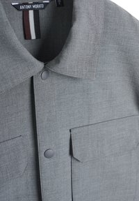 Grijze overhemden met een gestructureerde stof, een spread collar, twee voorzakken en een gestikt label met horizontale strepen.