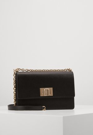 Bolso de mano de cuero negro texturizado con correa de cadena dorada y cierre rectangular dorado con logotipo en relieve en la solapa frontal.