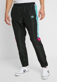 Sorte joggingbukser med elastisk talje, med turkise og lyserøde sideakcenter samt et hvidt logo. Stoffet virker glat og let.