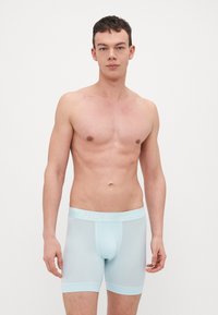 Lysblå Nike boxershorts med bred talje, glat tekstur og kort benlængde, med subtil branding i en matchende farve.