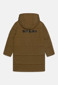 Λαδί μπουφάν με κουκούλα, ραμένο σχέδιο, και την λέξη "TIMBERLAND" σε μαύρο χρώμα στην πλάτη.