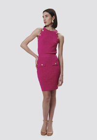 Fuchsia Kleid mit strukturiertem Muster, ausgestattet mit goldenen Knöpfen an den Schultern und zwei Taschen im Vorderteil des Rocks. Glatte Stoffoberfläche.