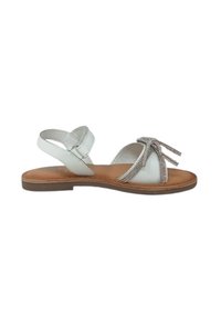 Sandal in pelle bianca con due cinturini e un dettaglio a fiocco, caratterizzata da accentuazioni metalliche e una suola piatta marrone.