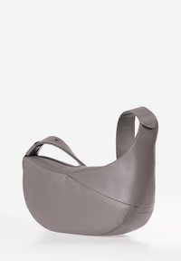 Borsa a spalla in pelle grigia con forma curvata, ampia tracolla singola e design minimalista caratterizzato da cuciture sottili e senza hardware visibile.