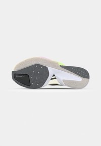 Sport shoe sole featuring a black and gray rubber outsole, textured patterns, and a white midsole with accents of neon yellow and pink.
