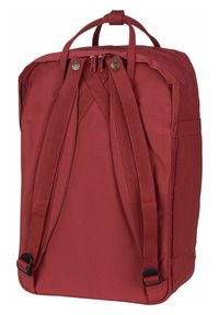 Mochila de tela roja con correas ajustables acolchadas, un asa superior, cierre con doble cremallera y bolsillos laterales para mayor almacenamiento. Textura suave.