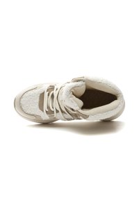 Ilgų mėgintuvėlių tan ir grietinėlės spalvos sportiniai bateliai su puriu pamušalu, kailio akcentais, apvaliu nykščiu ir baltais raišteliais. Viršutiniame paviršiuje matomi tekstūruoti skydeliai.