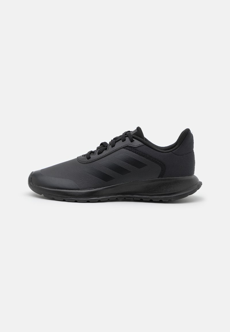 Scarpe sportive nere con una parte superiore testurizzata, caratterizzate da tre strisce nere sul lato, una suola imbottita e un design a punta arrotondata.