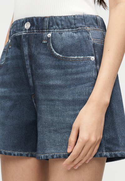 Shorts in denim con una tinta blu scuro, dotati di vita arricciata, due tasche frontali e dettagli di orlo sfrangiato.