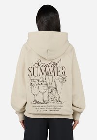 Beige hoodie with a large graphic on the back, featuring cocktails and the text "Scent of Summer" in brown. Soft fabric, relaxed fit.