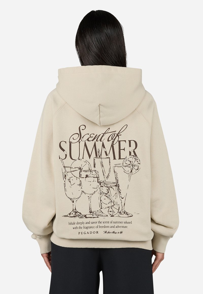 Beige hoodie with a large graphic on the back, featuring cocktails and the text "Scent of Summer" in brown. Soft fabric, relaxed fit.