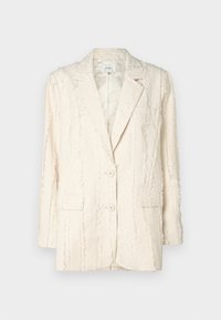 Blazer color crema con un patrón texturizado y con flecos. Cuenta con dos botones, un cuello con muescas y bolsillos laterales. Interior forrado.