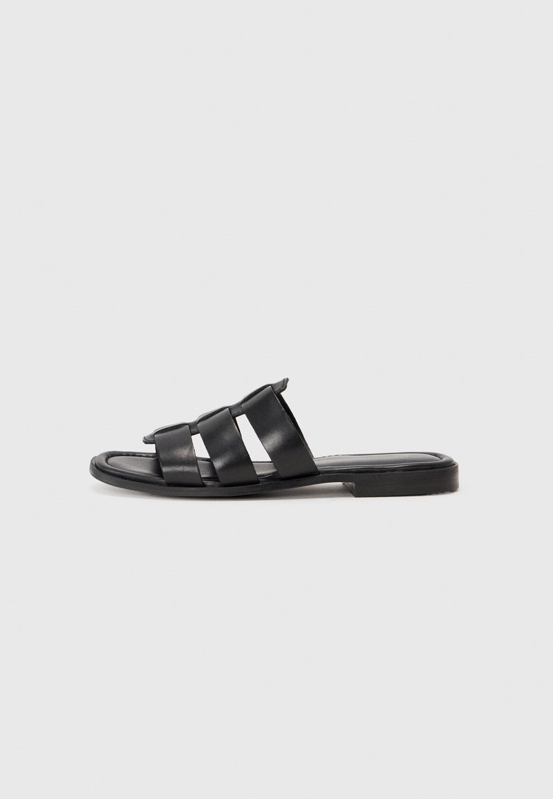 Black leather slide sandals with three wide straps, a flat sole, and soft texture. Simple design with minimal detailing.