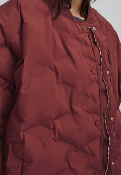 Burgundijas pūkauto krāsojums ar izšūtu dizainu, spiedpogas un rāvējslēdzēja aizdare. Izgatavots no gludas, izolējošas vielas ar izcelta logotipa.